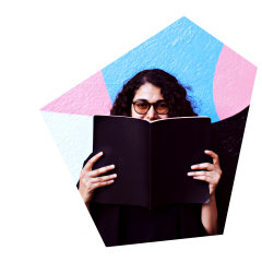 Woman holding up a book in front of her face with colourful wall