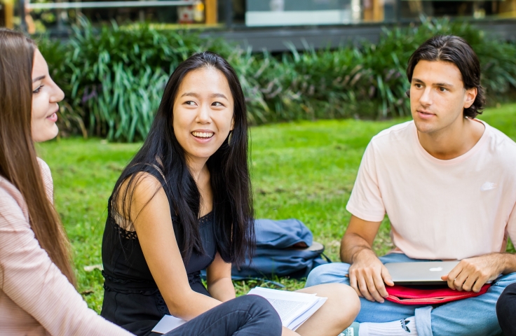 Three UNSW Law students sitting on the grass