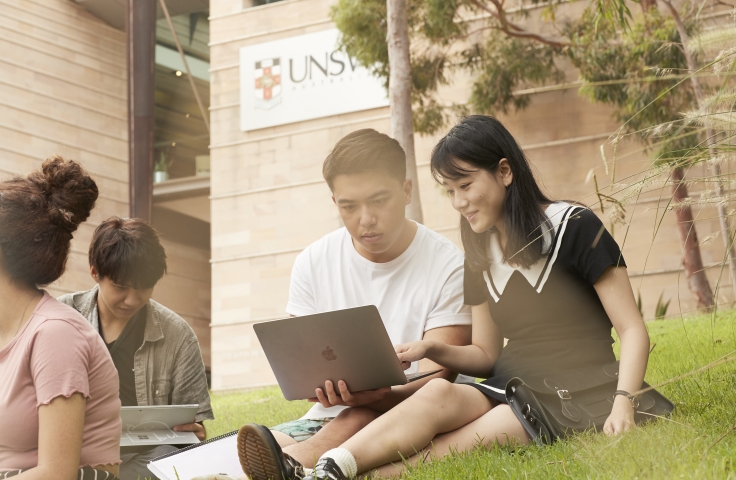 Two students sitting on UNSW main walkway